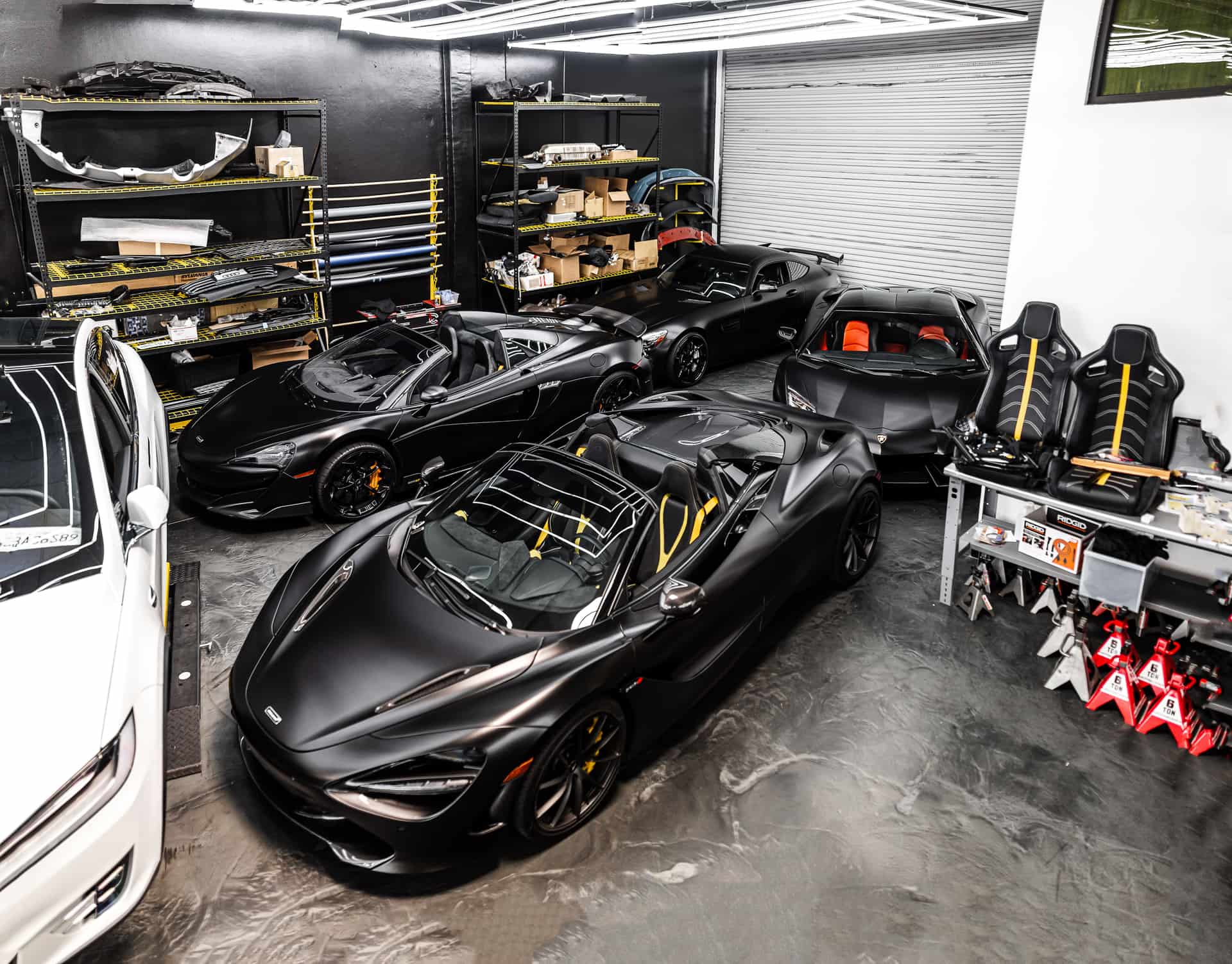 Dark prestige sports cars in a well-organised workshop