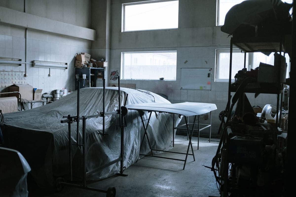 Cars under covers inside a bodyshop